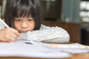Child struggling with homework during learning disorder testing in Colorado Springs.